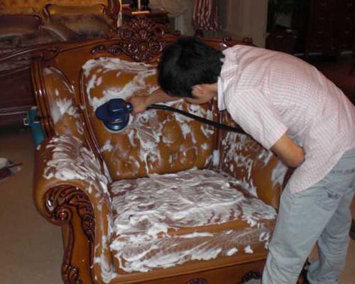 保洁员用设备清洗沙发